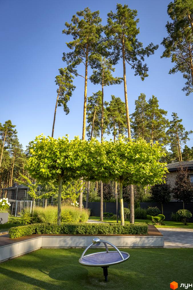 Котеджне містечко ZAHRAVA village 2. Зелена прибудинкова територія з деревами та дитячим майданчиком.