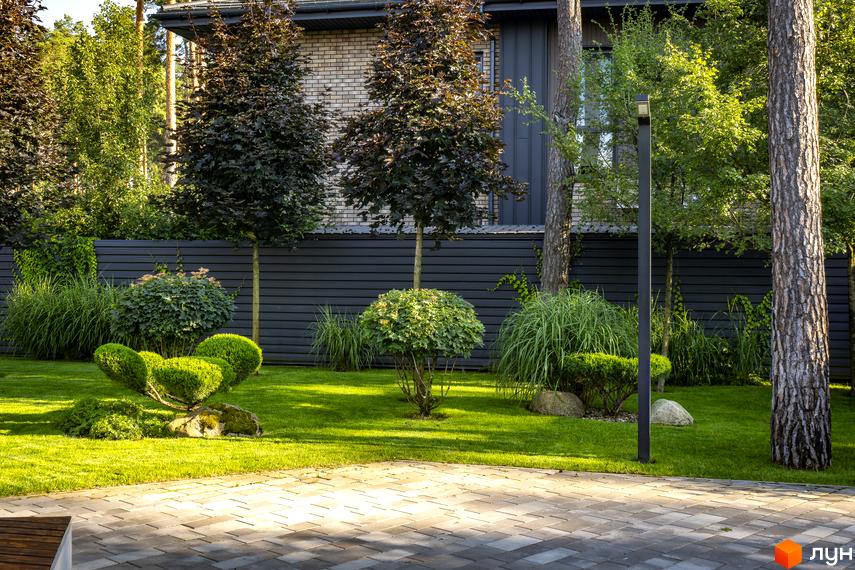 Котеджне містечко ZAHRAVA village 2. Зелений доглянутий двір з акуратно підстриженими кущами та деревами.