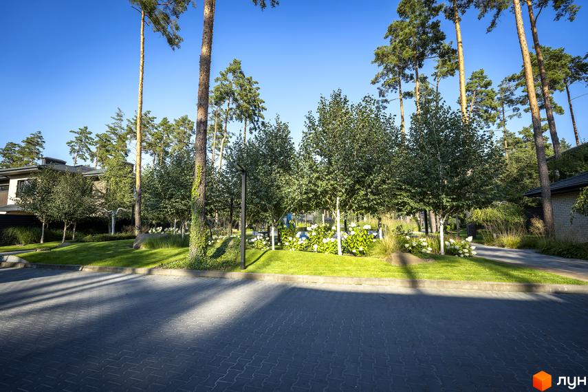 Котеджне містечко ZAHRAVA village 2. Зелена прибудинкова територія з деревами та квітами біля будинку.