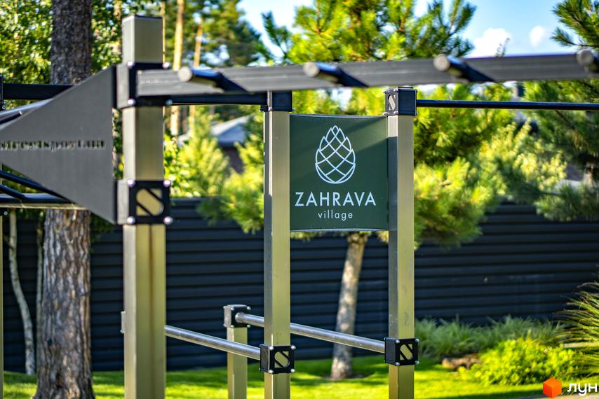 Спортивний майданчик на території котеджного містечка ZAHRAVA village. Навколо зелені дерева та газон.