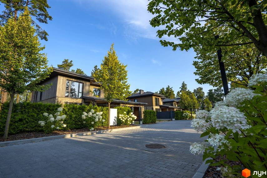 Котеджне містечко ZAHRAVA village 2. Сучасні будинки з дерев'яним фасадом та доглянутою прибудинковою територією з квітами та деревами.