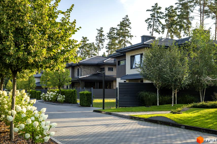 Котеджне містечко ZAHRAVA village 2. Зовнішній вигляд будинків з цегли та дерева, прибудинкова територія з доглянутими газонами та деревами.