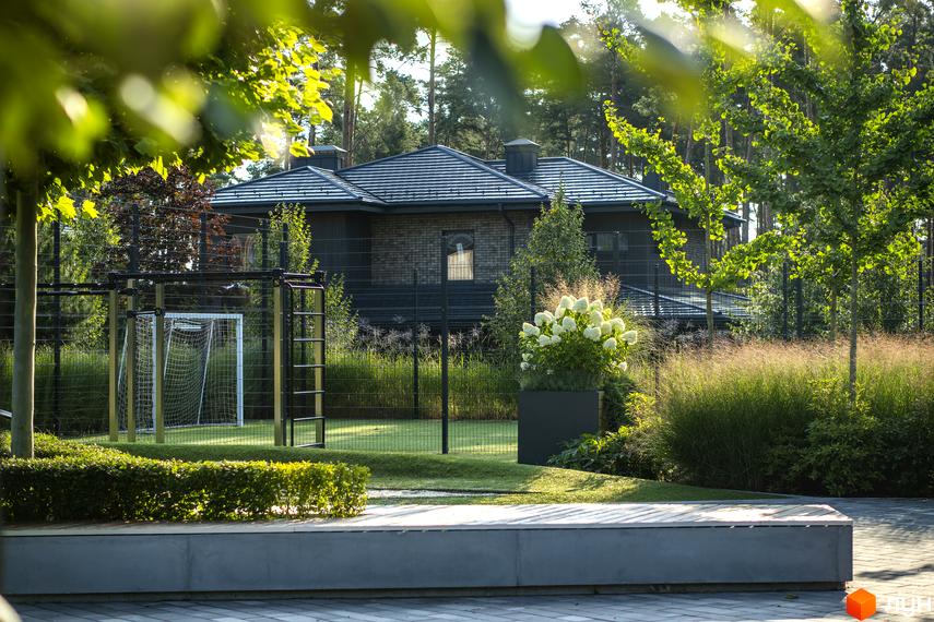 Котеджне містечко КМ ZAHRAVA village 2: двоповерховий будинок з цегляним фасадом та сірим дахом, поруч спортивний майданчик з футбольними воротами та зелена прибудинкова територія.