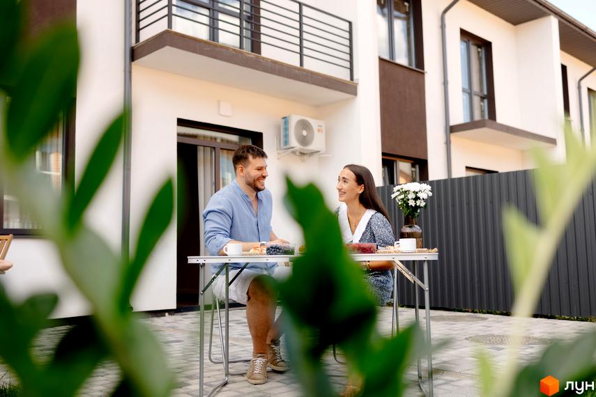 Котеджне містечко КМ WEST TOWN XIV: двоповерхові будинки з балконами та приватна територія з місцем для відпочинку.