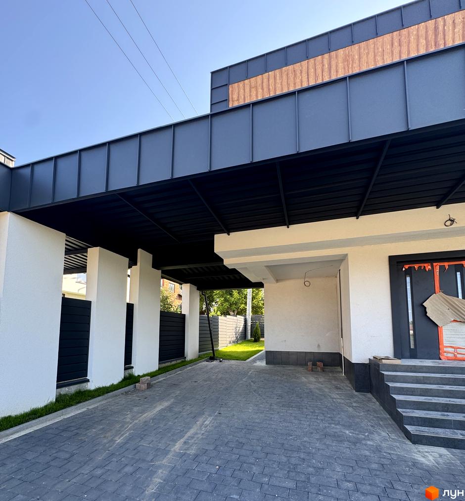 Котеджне містечко Lake House Sokilnyky: сучасний навіс над бруківкою та вхідна група будинку. Прибудинкова територія з газоном та парканом.