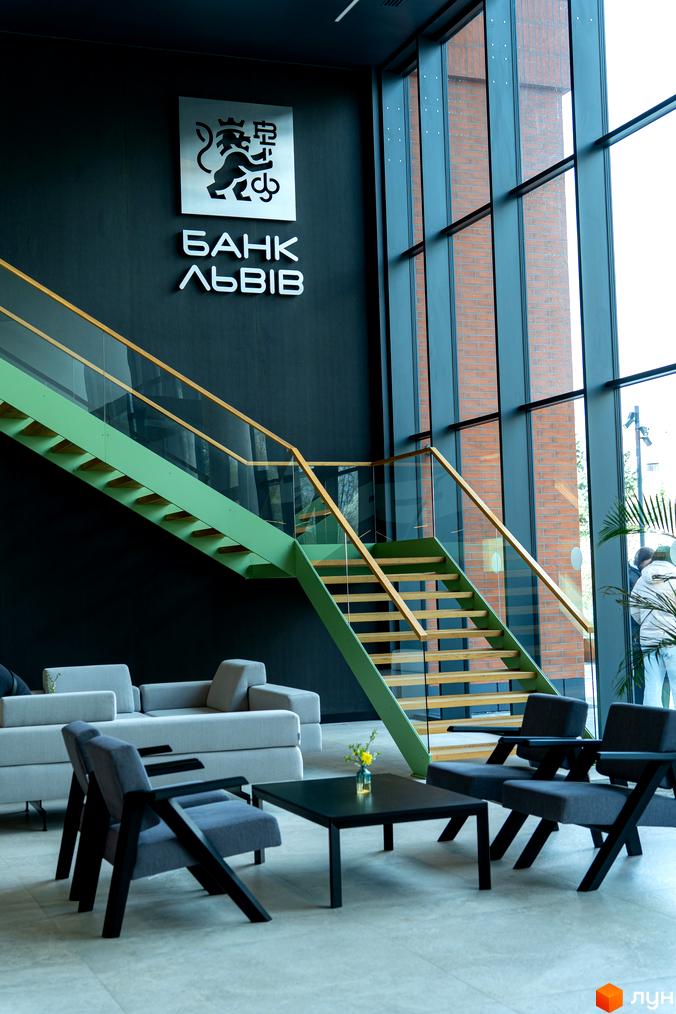 Сучасний інтер'єр банку з зеленою драбиною та сірими меблями. Апарт-комплекс Kristal Plaza.