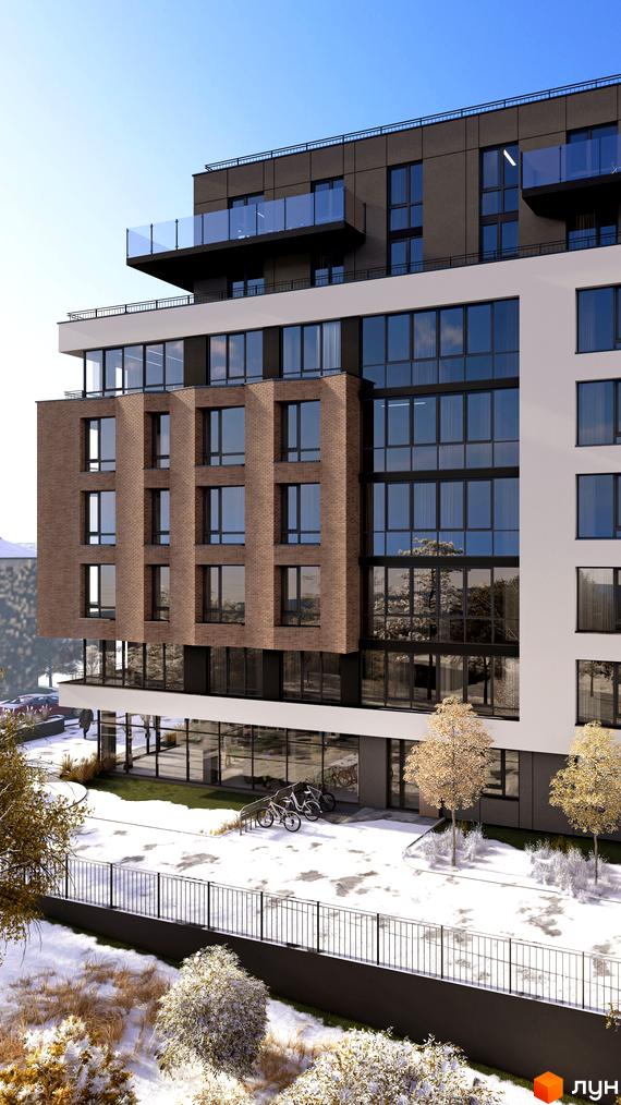 Зовнішній вигляд новобудови ЖК Поділля з цегляними та білими фасадами, великими вікнами та скляними балконами. Прибудинкова територія вкрита снігом, з деревами та огорожею.