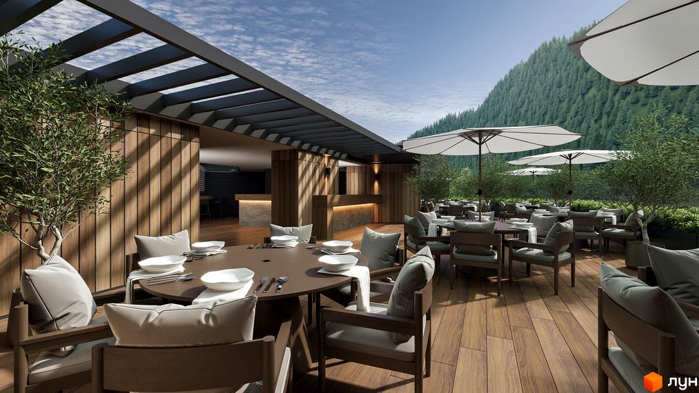 Тераса житлового комплексу Green Rest з дерев'яним покриттям, столами та кріслами, оточена зеленню та гірським пейзажем.