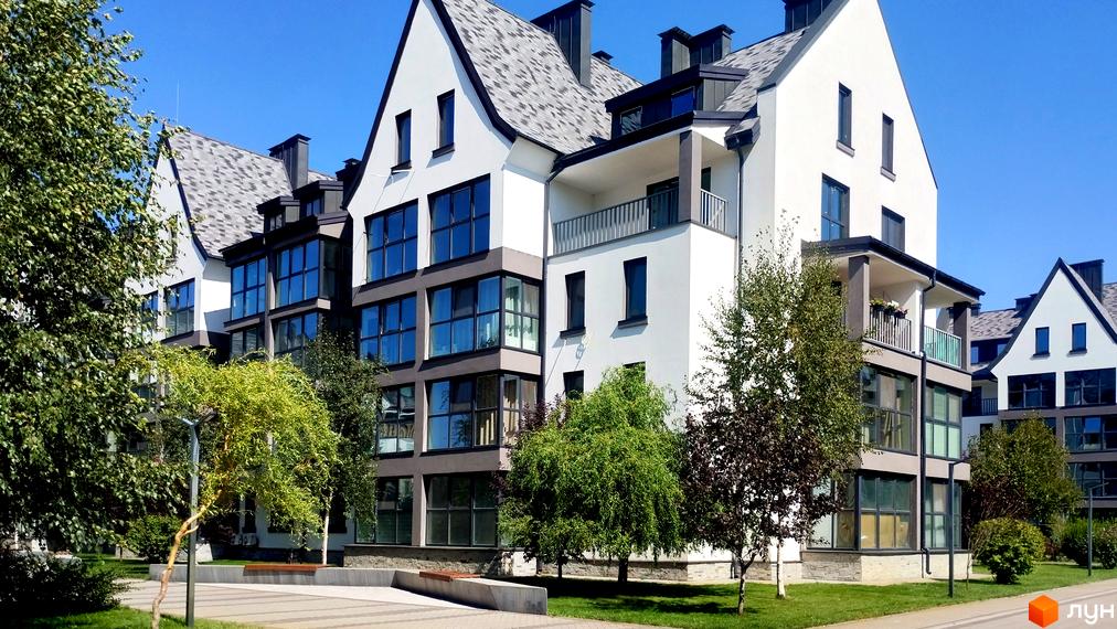 Зовнішній вигляд новобудови ЖК Desna Park Residence з великими вікнами та балконами, оточеної зеленими деревами та доглянутою прибудинковою територією.