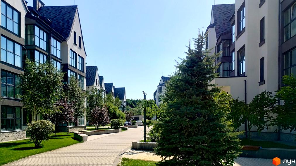 Житловий комплекс Desna Park Residence: фасади будинків з великими вікнами та акуратна прибудинкова територія з деревами та пішохідними доріжками.