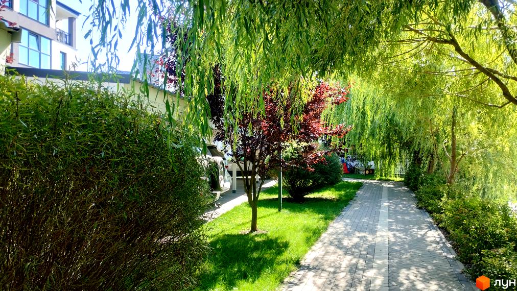 Житловий комплекс Desna Park Residence з доглянутою прибудинковою територією, вимощеною доріжкою та зеленню.