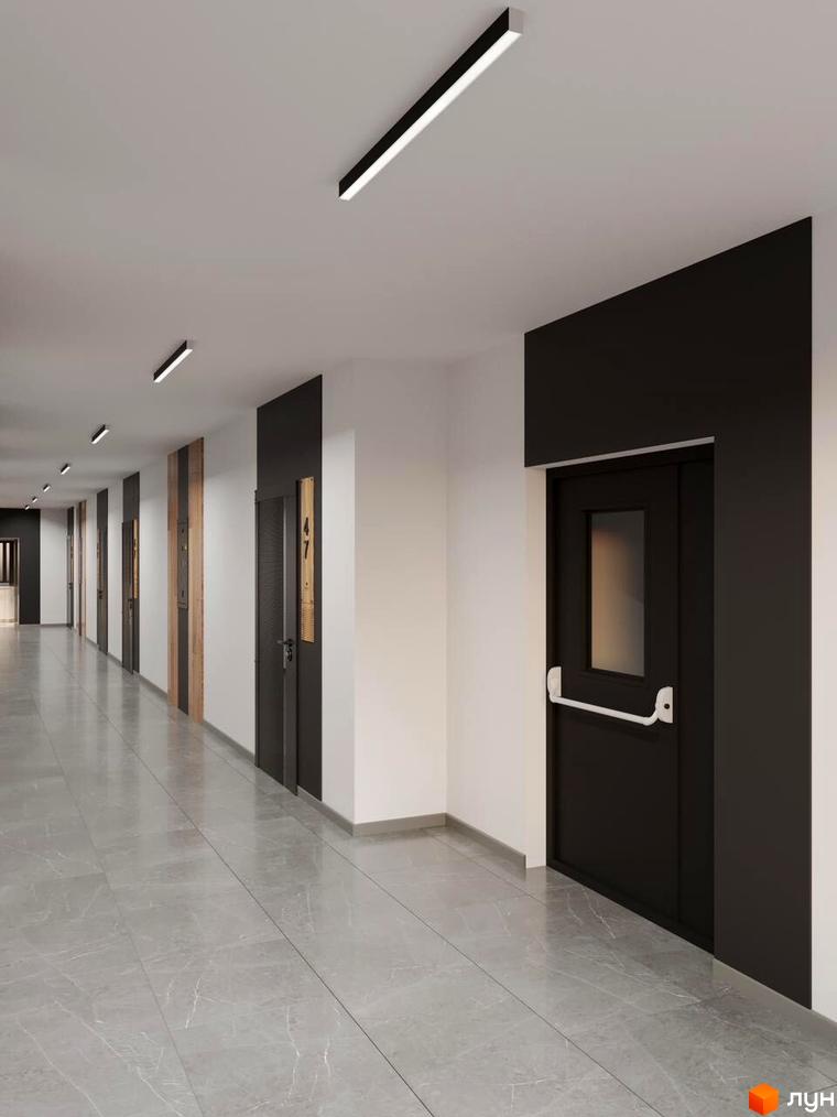 Коридор новобудови ЖК Кришталь з сірою мармуровою плиткою на підлозі та темними дверима. Освітлення забезпечують довгі лінійні світильники на стелі.