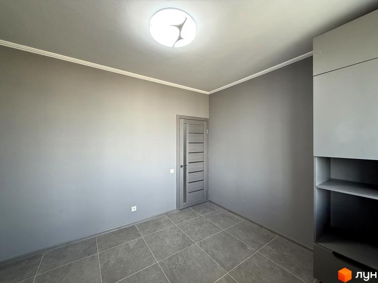 Житловий комплекс Центр: простора кімната з сірими стінами, дверима та шафою. Підлога покрита плиткою.