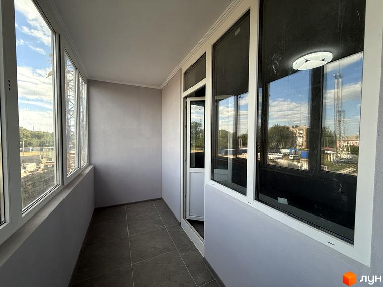 Балкон у ЖК Центр з панорамним склінням та видом на міську забудову. Сучасний дизайн та функціональне планування.