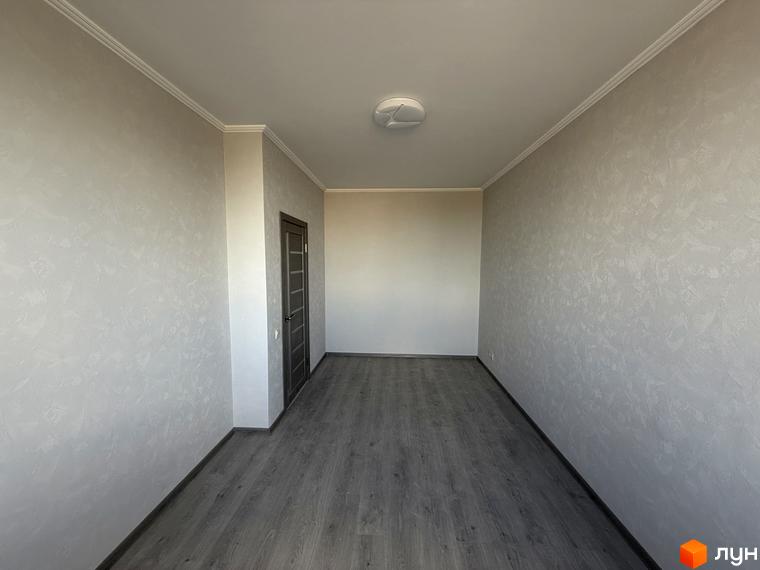 Житловий комплекс Центр: порожня кімната з сірими стінами, дверима та підлогою.