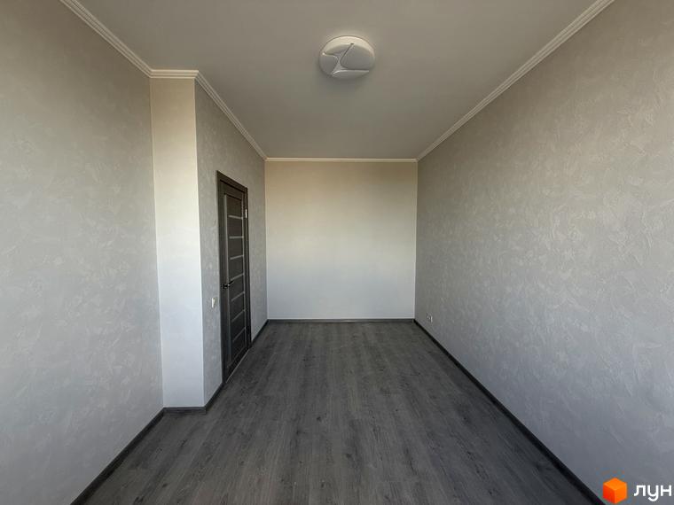 Житловий комплекс Центр: порожня кімната з сірими стінами та дверима, сірою підлогою та білою стелею.