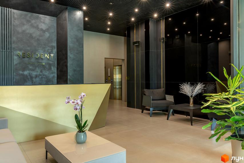 Лобі житлового комплексу Resident Concept House з золотистим ресепшн, зручними кріслами та елегантним дизайном.
