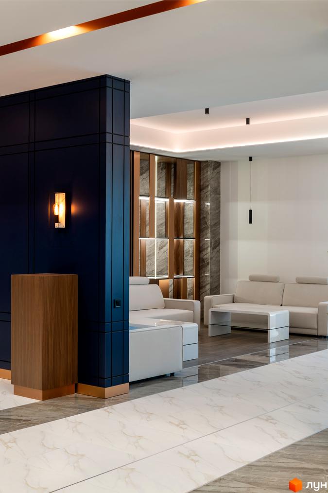 Інтер'єр холу житлового комплексу Edelweiss House з диванами та дизайнерським освітленням. Сучасний дизайн та оздоблення.