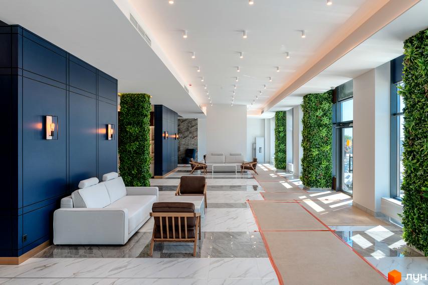 Інтер'єр лобі житлового комплексу Edelweiss House з вертикальним озелененням та стильними меблями. Сучасний дизайн та комфорт для мешканців.