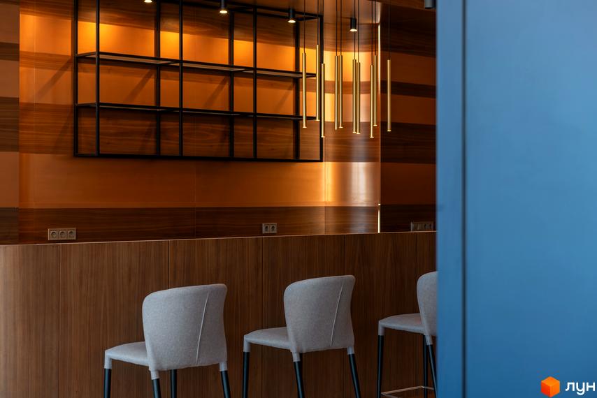 Інтер'єр бару з дерев'яними панелями та сірими стільцями. ЖК Edelweiss House - це новий будівельний проєкт з унікальним дизайном.