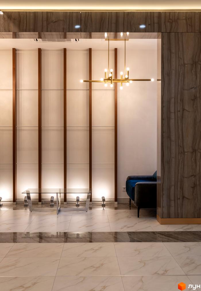 Інтер'єр ЖК Edelweiss House з мармуровою плиткою на підлозі та елегантною люстрою. Сучасний дизайн простору для комфортного життя.