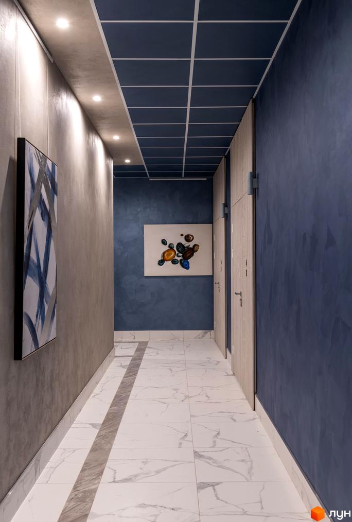 Коридор у новобудові ЖК Edelweiss House з мармуровою підлогою та абстрактним живописом на стінах. Стильний дизайн інтер'єру.