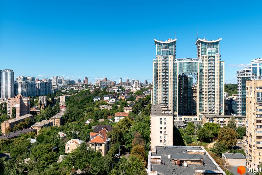 Вид на житловий комплекс Edelweiss House з двома високими вежами, з'єднаними аркою, та зеленою прибудинковою територією.