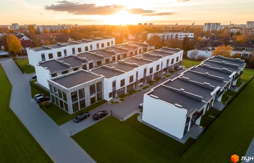 Житловий комплекс Orange Home: сучасні таунхауси з пласкими дахами та великими вікнами, оточені зеленими газонами та дорогою.