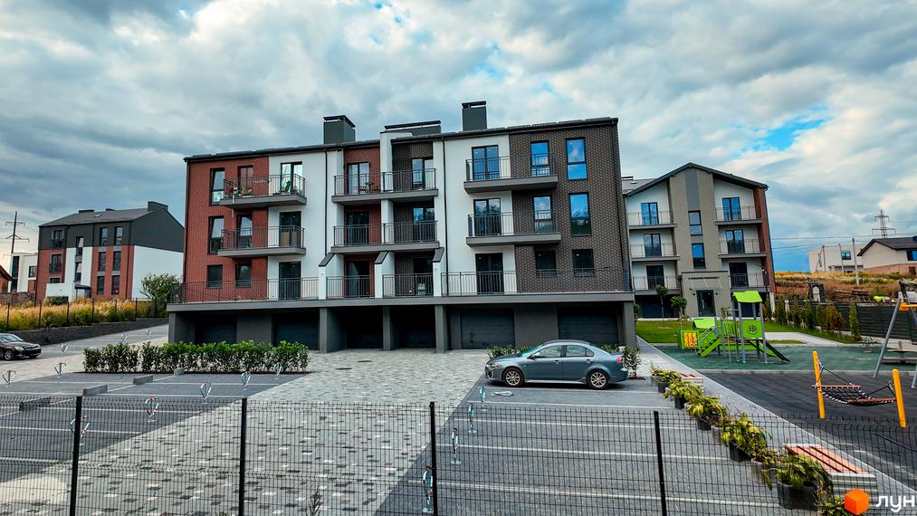 Житловий комплекс Вілла Швейцарія – це сучасна новобудова з цегляним фасадом та балконами, поруч розташований дитячий майданчик.