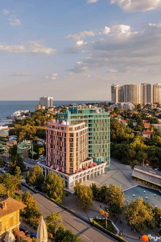 ARCHOTEL AVENUE - новобудова з рожевою та бірюзовою фасадами, розташована біля моря. Навколо зелена зона та міська інфраструктура.