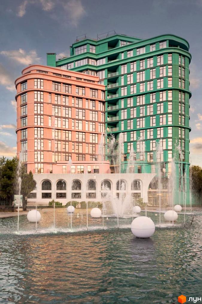 Житловий комплекс ARCHOTEL AVENUE з рожевою та зеленою будівлями, фонтанами та сферичними об'єктами у воді.