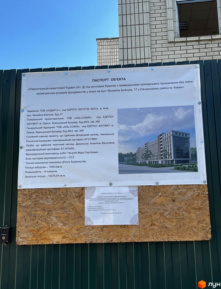 Реконструкція нежитлової будівлі під житловий будинок з приміщеннями громадського призначення на вул. Михайла Бойчука, 17. Фасад будівлі з вікнами та прибудинкова територія з деревами.