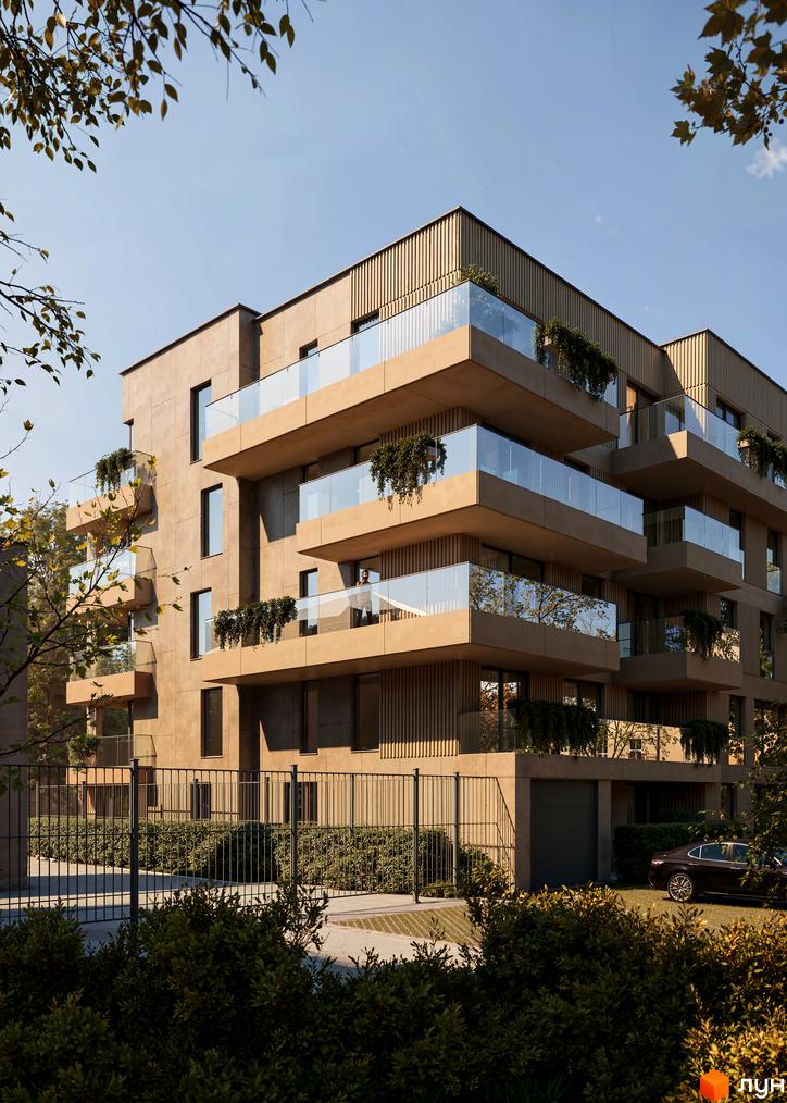 Новобудова Bernard Gallery з балконами та скляними огорожами, оточена зеленню та парканом. Поруч розташована дорога та автомобіль.