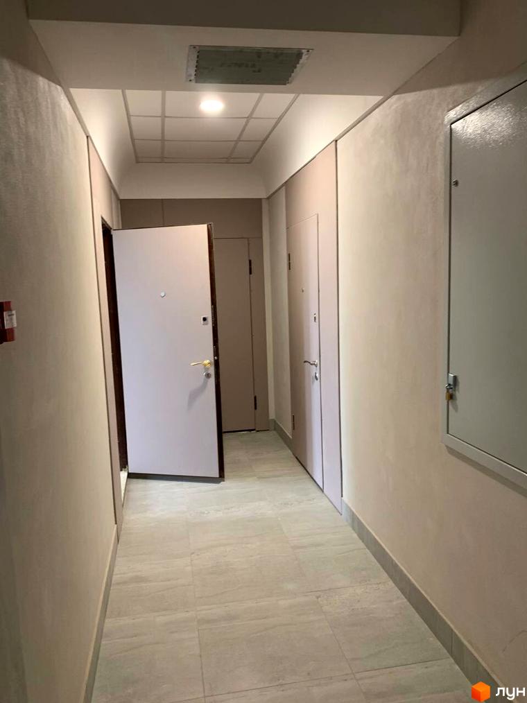 Комплекс Будинок на Маланова, вхідна група з дверима та коридором. Оздоблення стін та підлоги в світлих тонах.