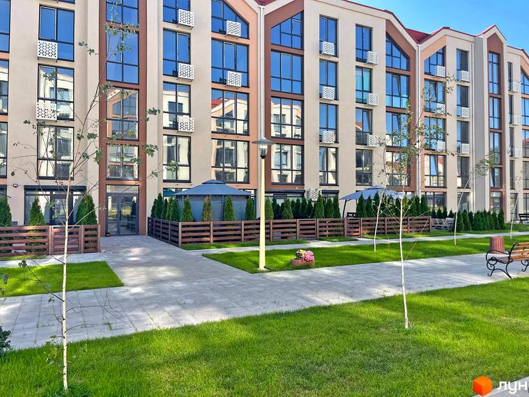 Зовнішній вигляд новобудови ЖК Smart Residence з великою кількістю вікон та прибудинковою територією з зеленими насадженнями та доріжками.