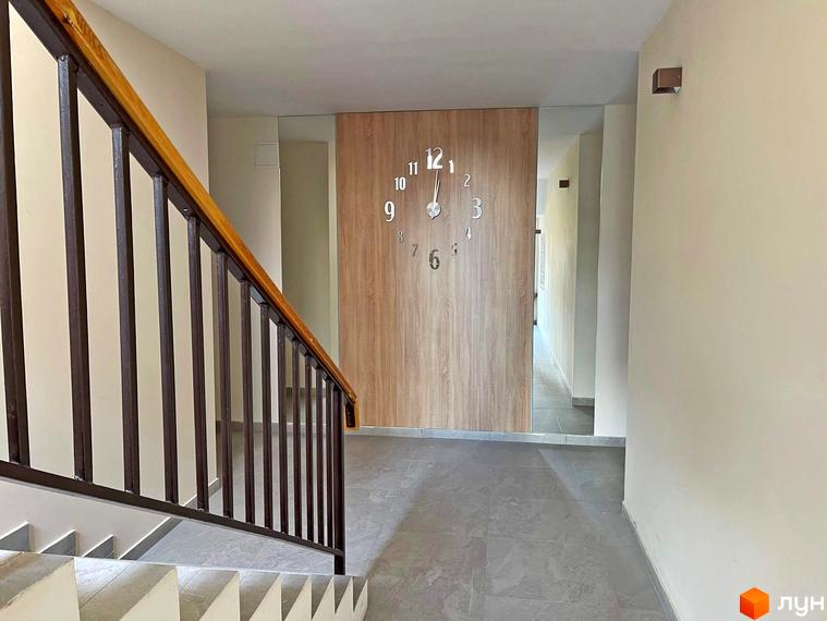 Комплекс Smart Residence: сходова клітка з перилами та годинником на стіні. Внутрішній вигляд новобудови.