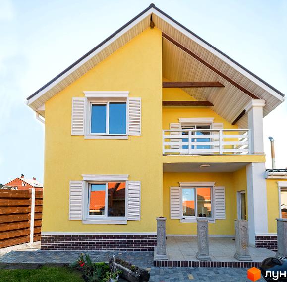 Двоповерховий будинок жовтого кольору з білими вікнами та балконом. Котеджне містечко Garden Street з доглянутою територією, бруківкою та зеленим газоном.