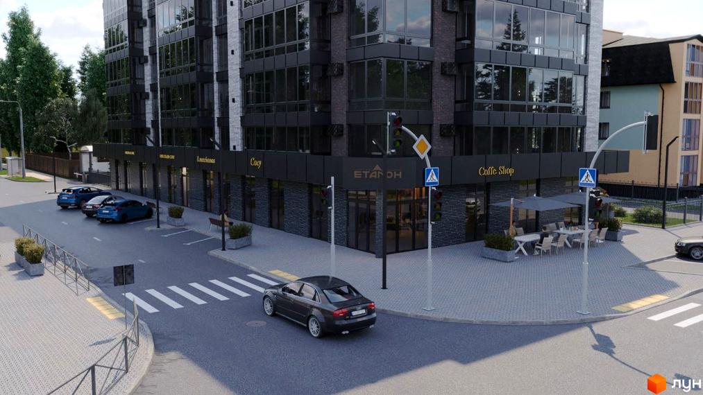 Зовнішній вигляд новобудови бул. Шевченка, 22, з фасадом з темної цегли та великими вікнами. Прибудинкова територія з пішохідним переходом та місцями для паркування.