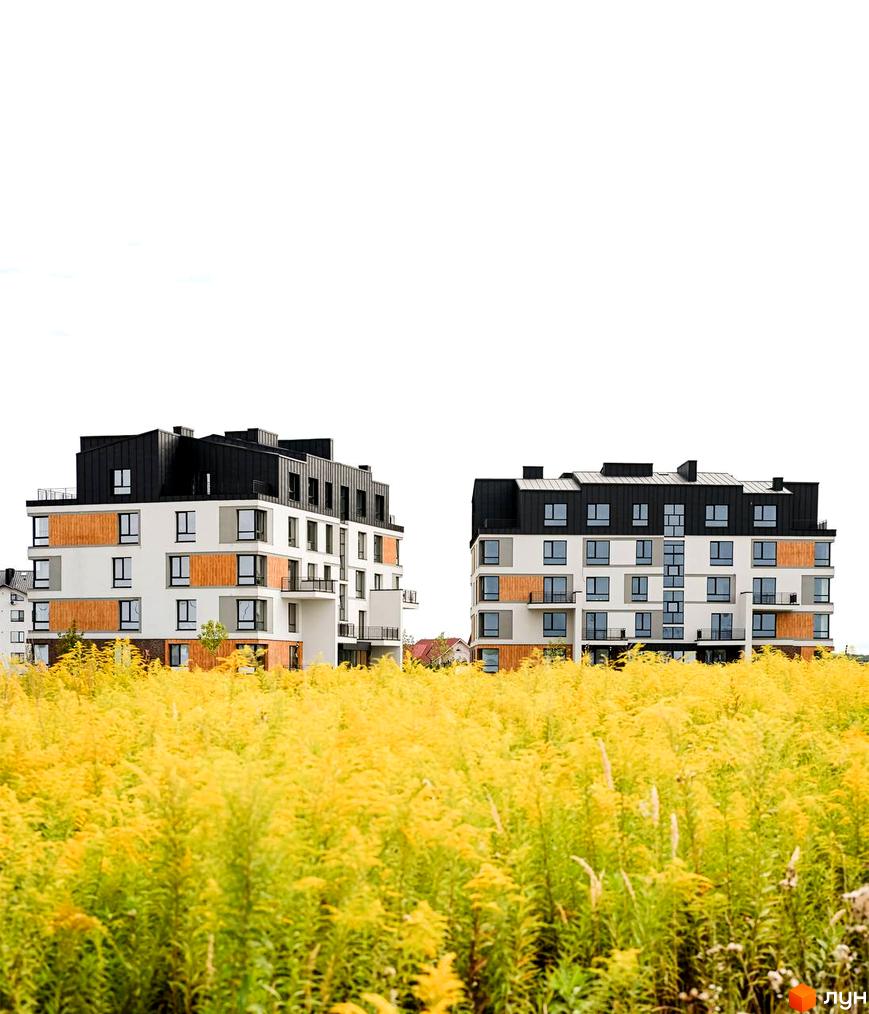 Новобудова ЖК Haute Couture з біло-сірими фасадами та дерев'яними вставками, оточена полем жовтих квітів.