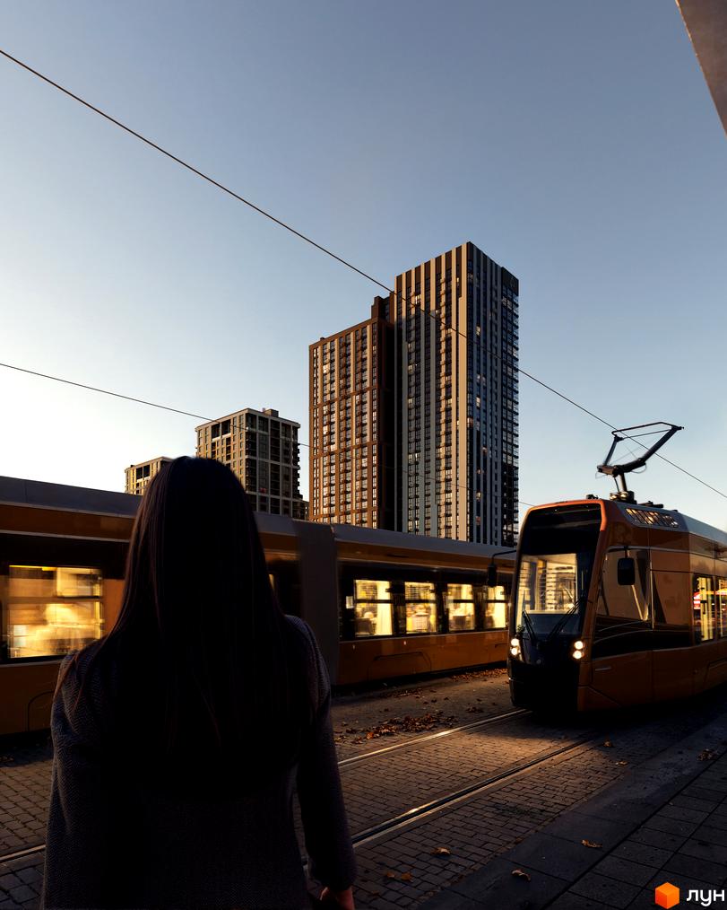 Житловий комплекс Avalon Up з сучасними висотними будинками та трамвайними коліями на тлі ясного неба. На передньому плані видно жінку, що стоїть біля трамвая.