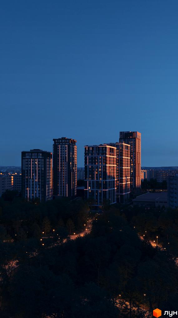 Житловий комплекс Avalon Up з підсвіченими фасадами ввечері, оточений темним парком з ліхтарями.