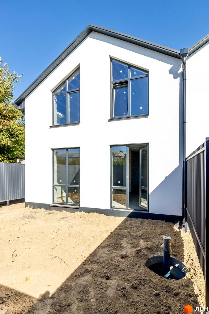 Таунхауси Small Town: білий двоповерховий будинок з великими вікнами та прибудинкова територія з піском та парканом.