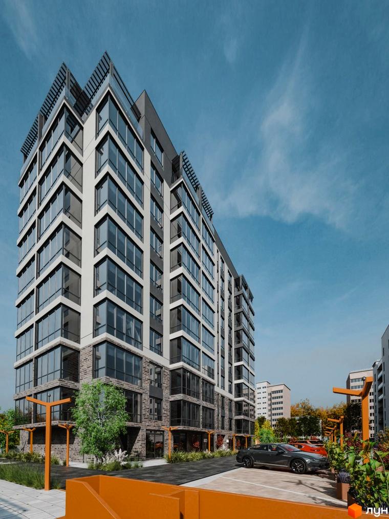 Зовнішній вигляд житлового комплексу Перемога з великою кількістю скління та цегляною обробкою нижніх поверхів. Прибудинкова територія з парковкою та зеленими насадженнями.