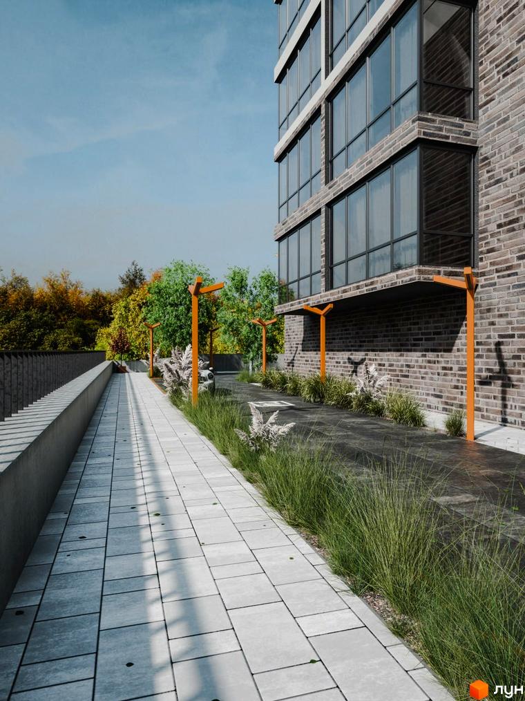 Зовнішній вигляд новобудови ЖК Перемога з цегляним фасадом та великими вікнами, поруч вимощена алея та зелені насадження.