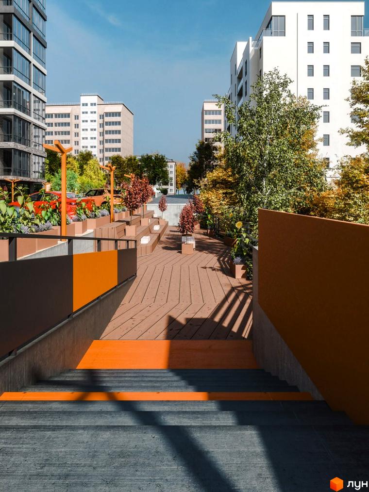 Житловий комплекс Перемога: фасади білих та сірих будівель, зелені дерева та облаштована прибудинкова територія з дерев'яними настилами та зонами відпочинку.