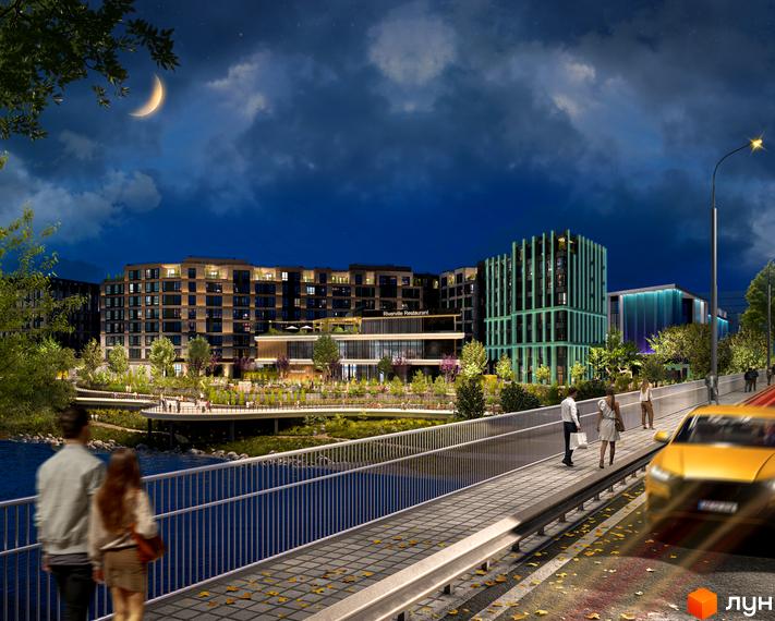 Житловий комплекс RIVERVILLE вночі з підсвіченими фасадами та зеленою зоною біля річки. Набережна з пішохідною зоною та міст з людьми.