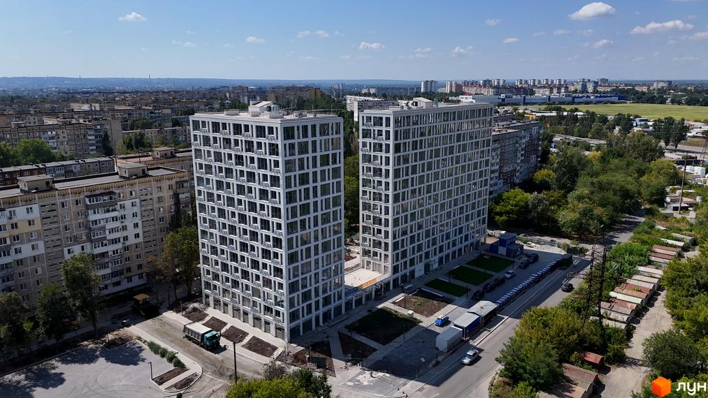 Житловий комплекс Вертикаль: дві висотні білі будівлі з численними вікнами, поруч зелена територія та міська забудова.