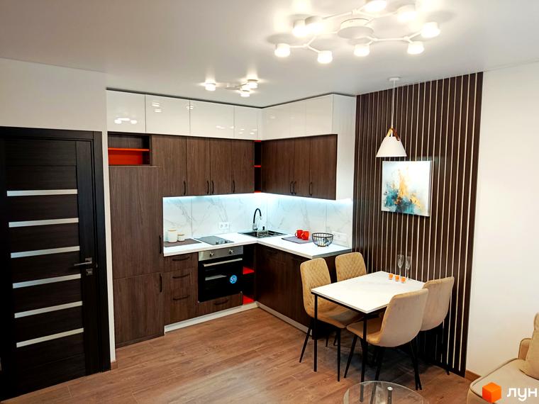 Інтер'єр кухні-вітальні з обідньою зоною в новобудові ЖК Вертикаль. Сучасні кухонні меблі, обідній стіл з чотирма стільцями, декоративне панно на стіні.