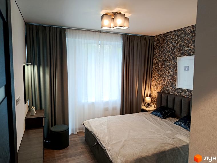 Житловий комплекс Вертикаль: затишна спальня з двоспальним ліжком, темними шторами та квітковими шпалерами. Вікно з білими тюлевими шторами.