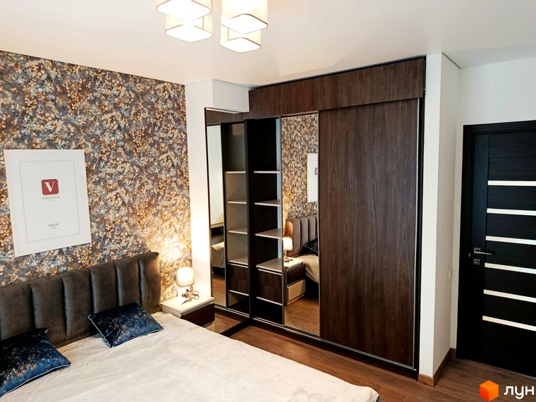 Спальня в квартирі ЖК Вертикаль з двоспальним ліжком, шафою-купе з дзеркальними дверима та шпалерами з квітковим принтом.